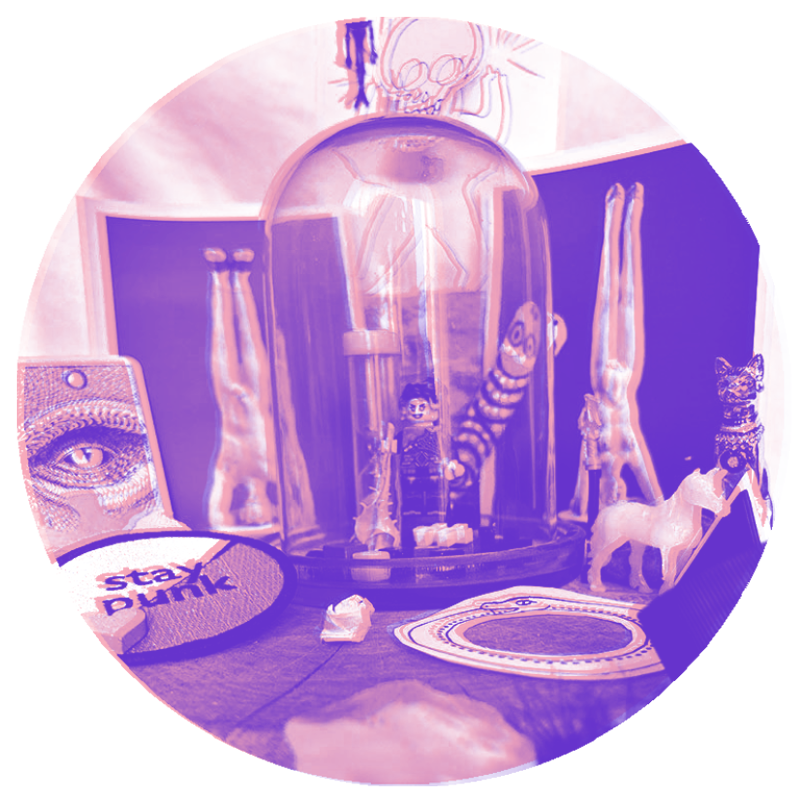 The first Rebel Altar with two art post cards with two figures standing on its head, a dragon eye card, a Stay Punk Patch, a unicorn, a golden statue of Egyptian cat Bastet, a rebellious LEGO figure.